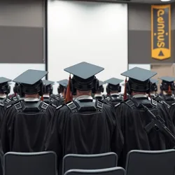 Graduation ceremony featuring traditional cap and gown with integrated armor plating